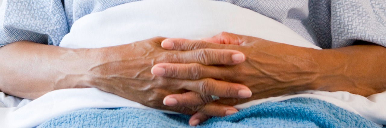 Does Racial Bias in the Medical Community Affect Me? woman sitting in hospital bed with hands folded