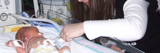Mia and her husband visiting their daughter in the Cardiac Intensive Care Unit when she was a day old.