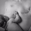 A black and white photo of the author breastfeeding after her single mastectomy