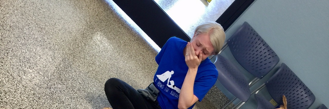 Mom's Reaction to Watching Her Autistic Son Meet His New Service Dog Mother crying and holding a hand to her mouth as her son lies against his new service dog