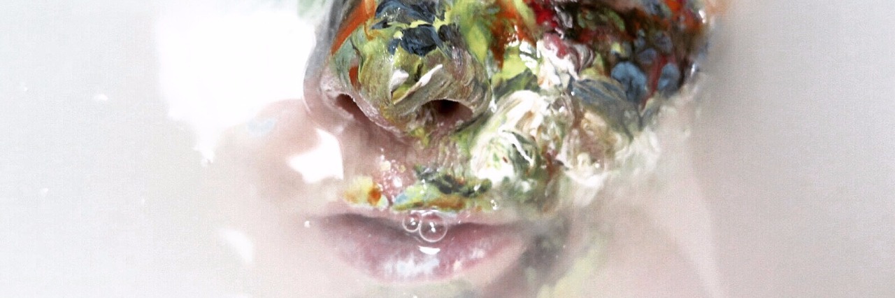 Liz Atkin Uses Compulsive Skin Picking As Inspiration for Her Artwork Face with one side covered in paint.