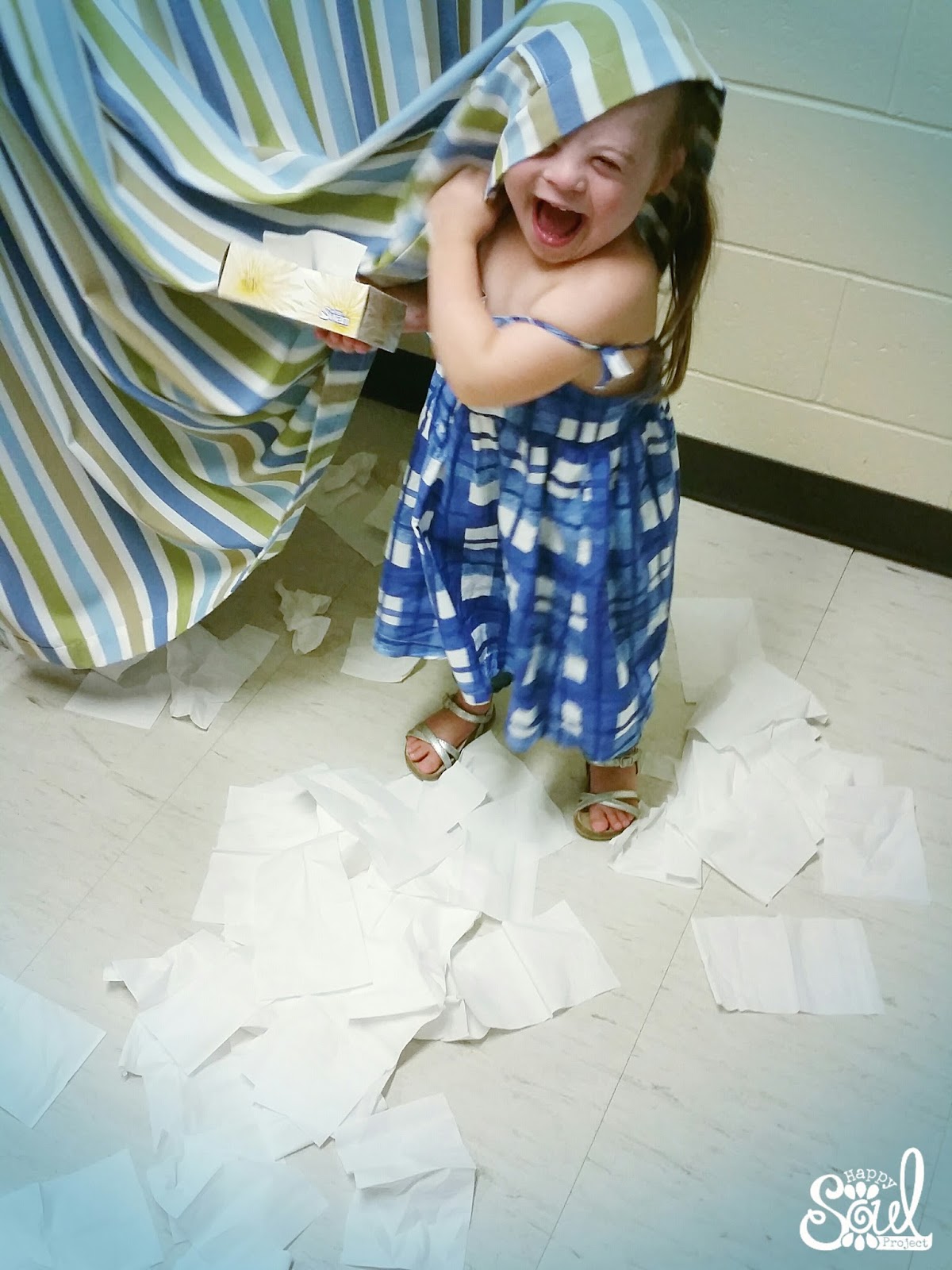 little girl playing with tissues