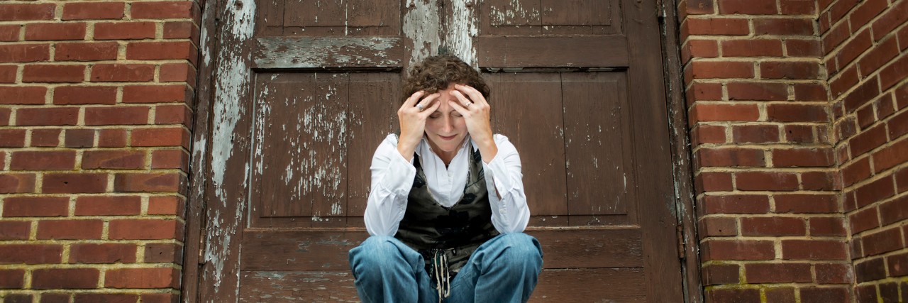 What It's Like to Live With 'High-Functioning' Autism woman upset in front of a brick wall