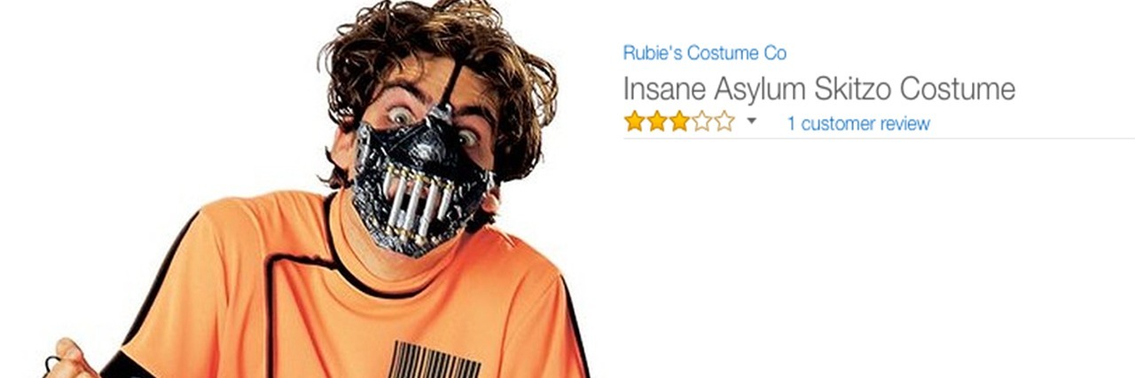 A man dressed is a jumpsuit with a scary mask. Text reads: Insane Asylum Skitzo Costume