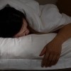 woman sleeping face down with hand outside blanket