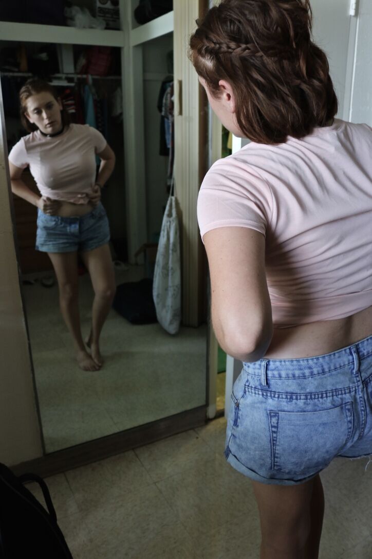woman staring at herself in the mirror