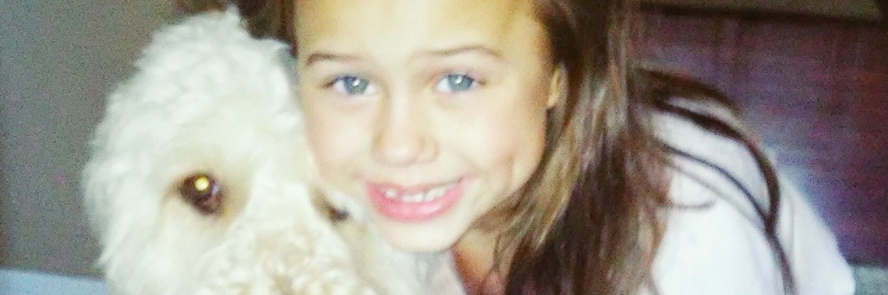 My Daughter on the Autism Spectrum Was Misunderstood by Another Mom a young girl standing with her service dog