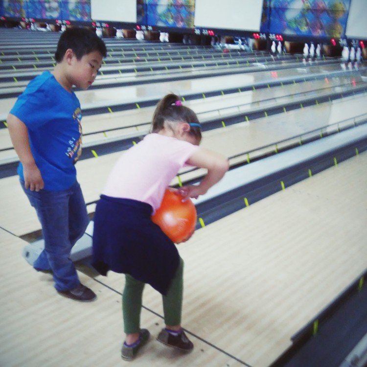 young boy and girl bowling