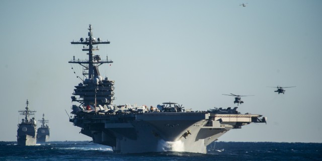 U.S. Navy MH-60 Seahawk helicopters prepare to land aboard the aircraft carrier USS George H.W. Bush (CVN 77), foreground, as the ship leads the guided missile cruisers USS Philippine Sea (CG 58), far left, and USS Leyte Gulf (CG 55) during operations in the Atlantic Ocean Dec. 13, 2013. The ships were part of the George H.W. Bush Carrier Strike Group and were underway participating in a final evaluation problem in preparation for a scheduled deployment. (DoD photo by Mass Communication Specialist 2nd Class Justin Wolpert, U.S. Navy/Released)