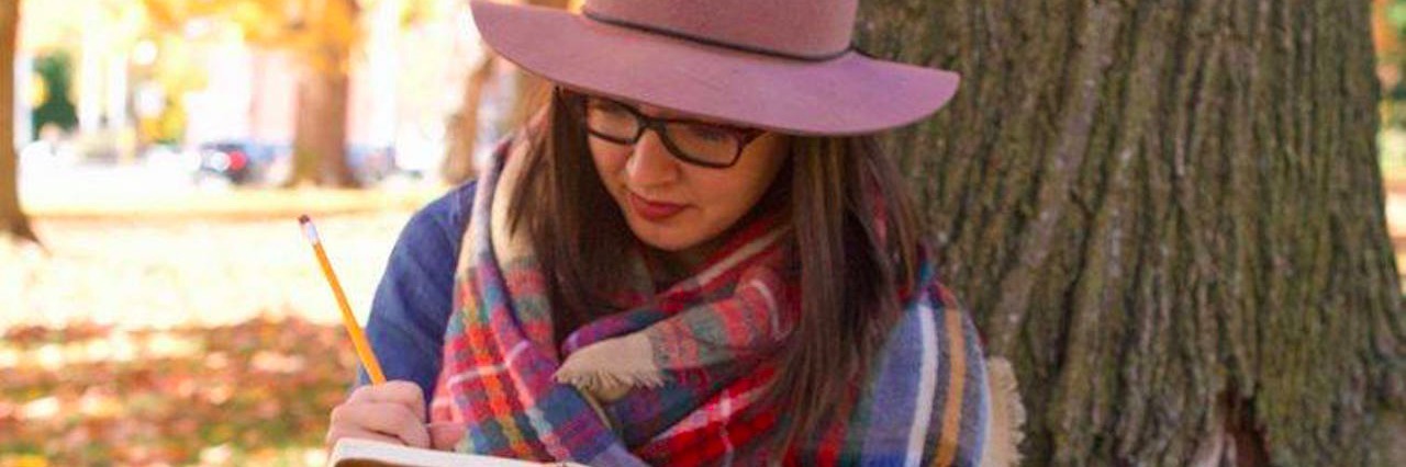 Breaking Up Letter to Depression A woman sitting by a tree writing in her journal