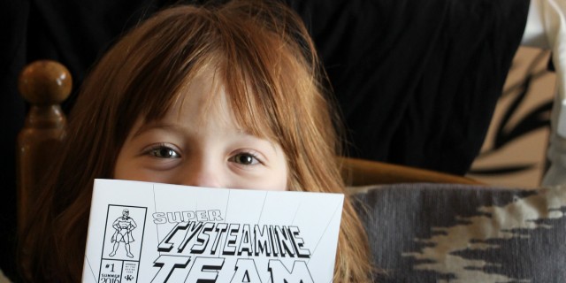 Making Cystinosis Cool With Comic Books little girl holding up comic book