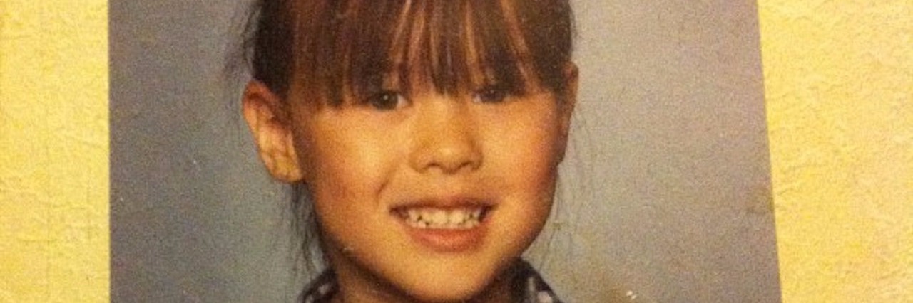 school photo of young girl with bangs and plaid shirt