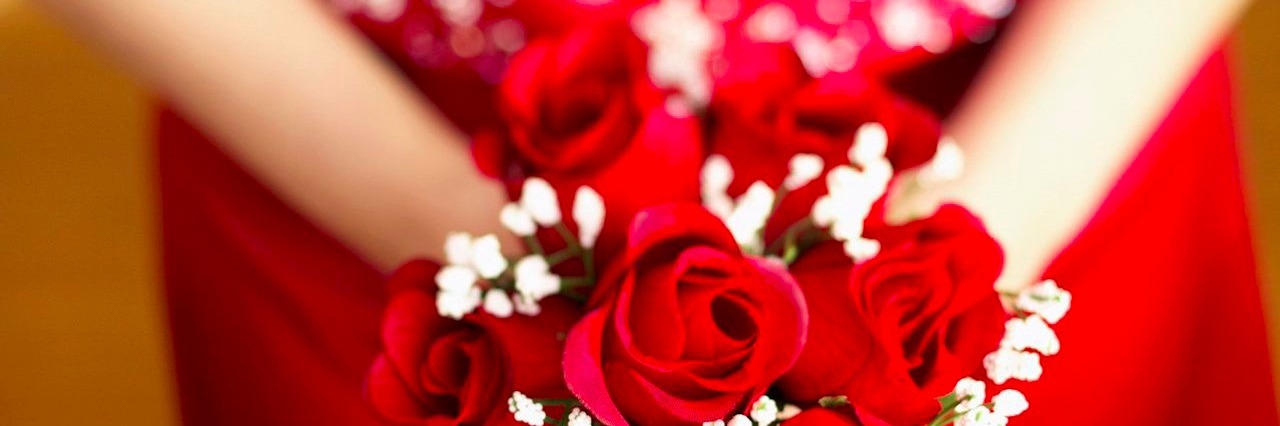 I Went to Prom Even Though My Medication Changed My Body woman wearing a red dress with a bouquet