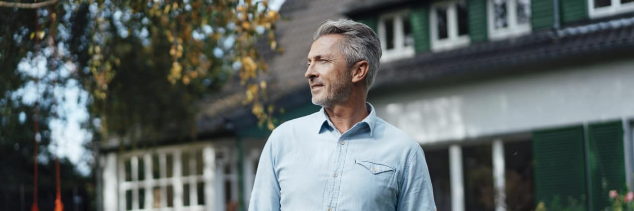Men and Fibromyalgia: Diagnosis and Symptoms Man with hands in pockets standing in front of a blurred house