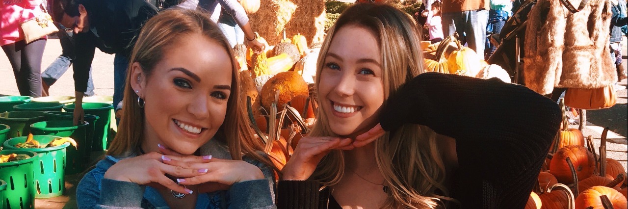 Why I'm Thanking My Diseases This Thanksgiving two women holding pumpkins on their laps