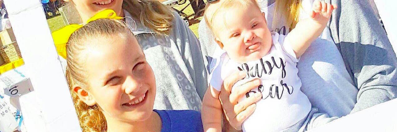 The Positive Step Doctors Can Take After a Down Syndrome Diagnosis instagram photo of a family with a mother and three daughters