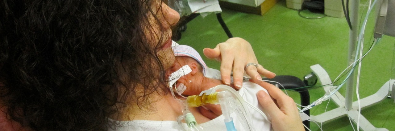 Processing Your Baby's Premature Birth and NICU Experience Mom holding her baby in the NICU