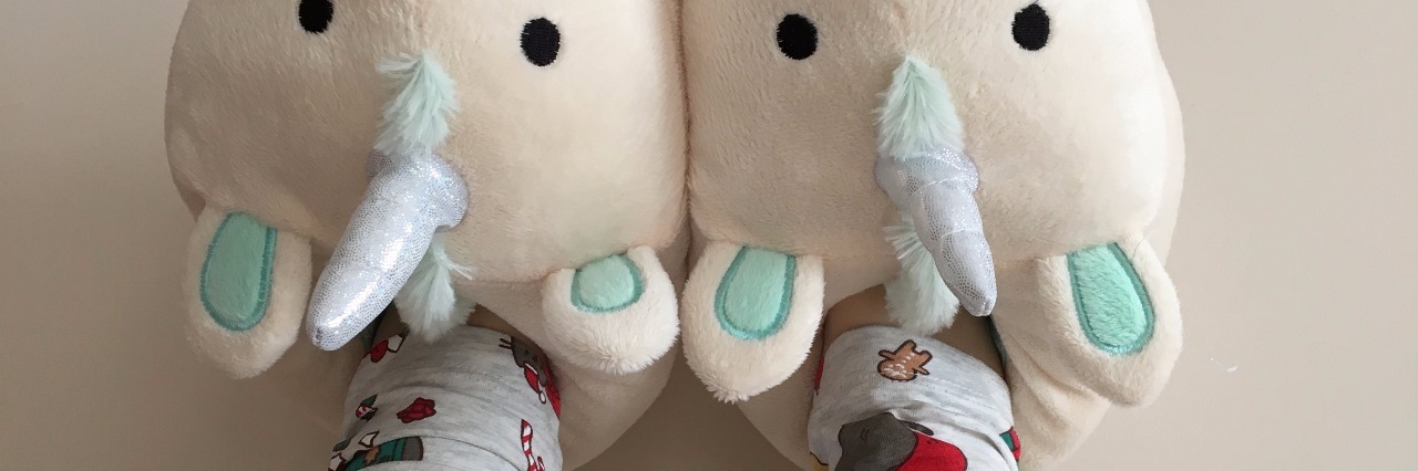Photo of person's feet wearing unicorn slippers