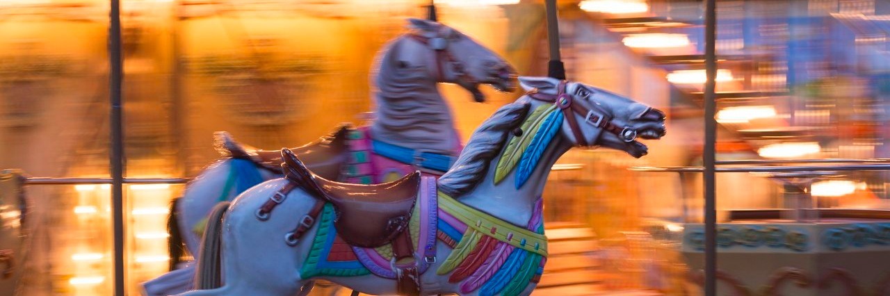 two white horses on a merry-go-round in motion