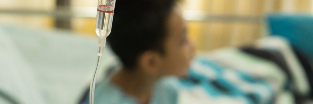 boy in hospital with a saline IV drip