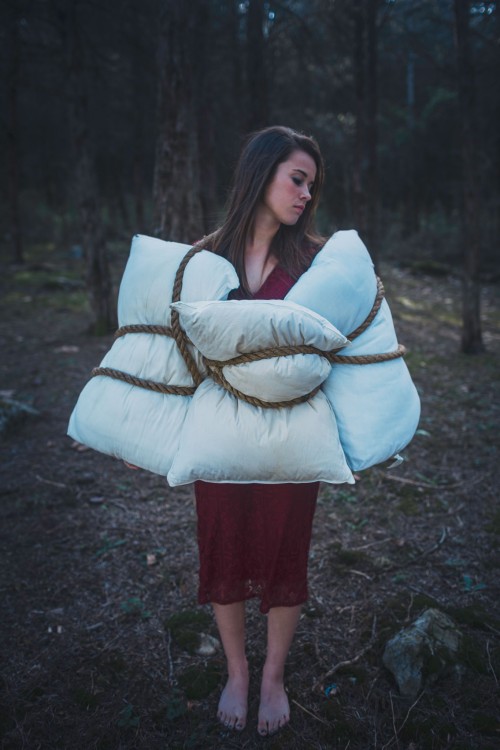 woman standing with pillows tied around her