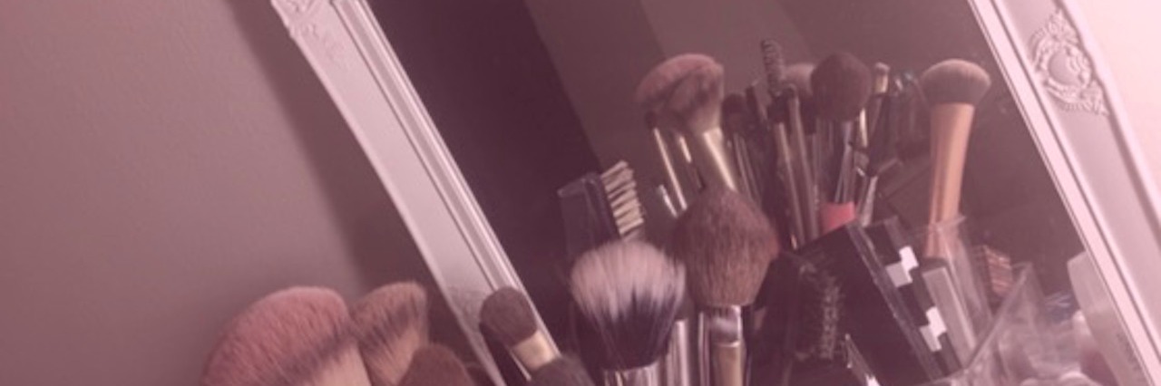 Wearing Makeup as a Woman Who Is Always Sick makeup supplies on dresser reflected in mirror