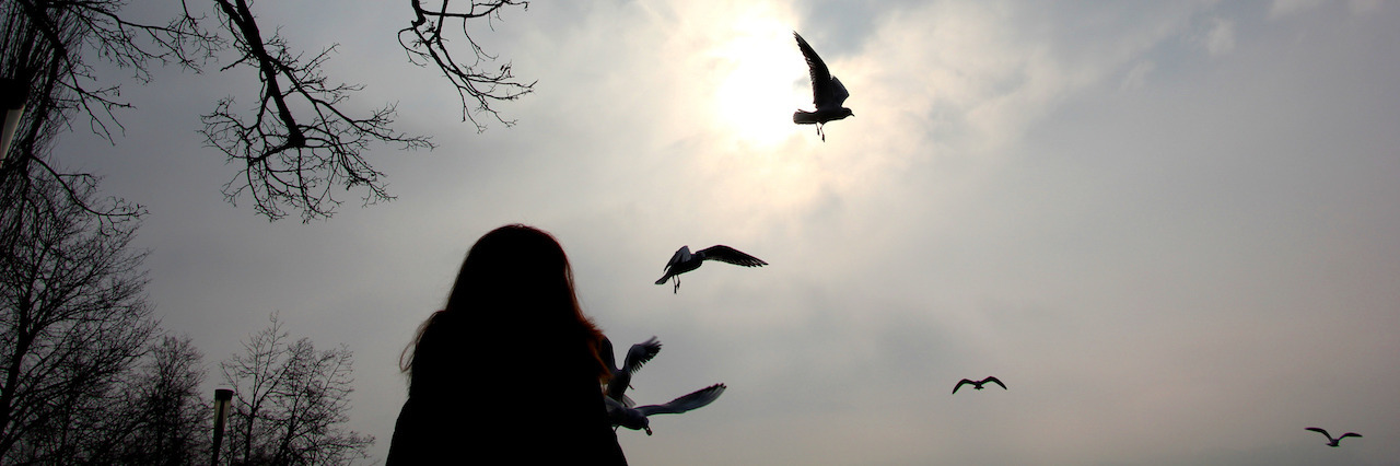 Finding Out a Friend Died of an Eating Disorder woman watching the birds on a cold winter day