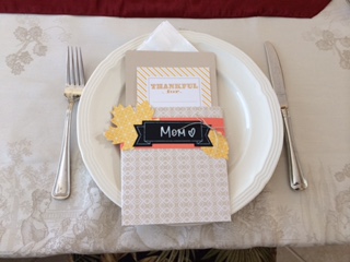 a place setting at a table with a card that says mom