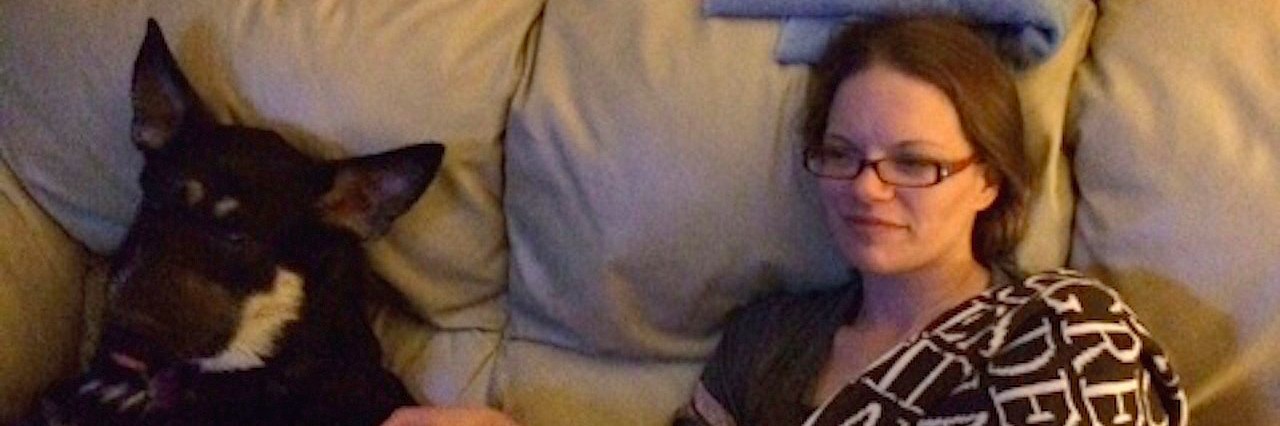 Things Doctors Shouldn’t Say to a Person With a Chronic Illness woman sitting on a couch with her dog