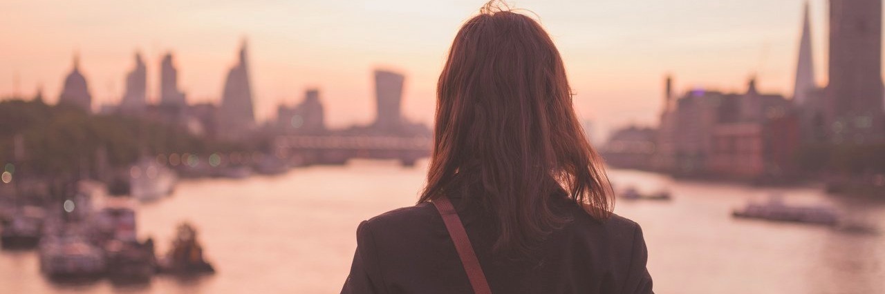 young woman admiring London at sunrise