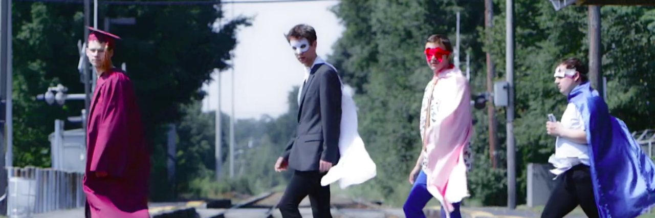 'Aspergers Are Us' Documentary on iTunes and Coming to Netflix Members of Aspergers Are Us dressed in costumes walking along a railroad track