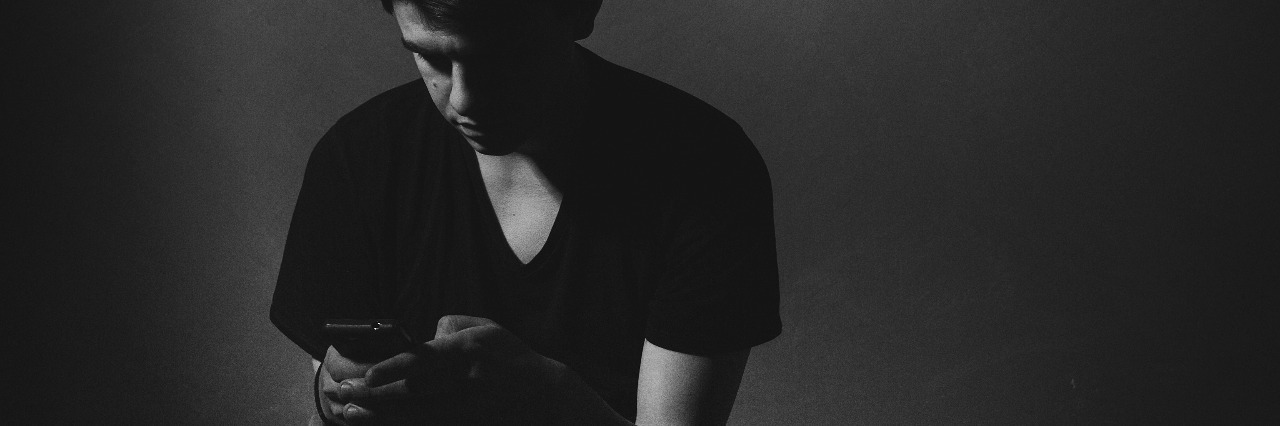 Black and white photo of young man texting