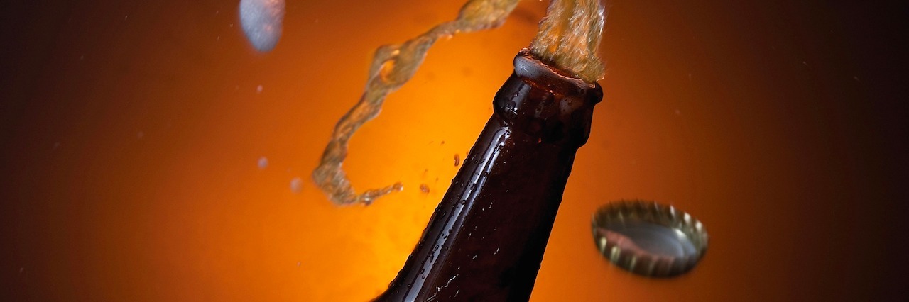beer bottle with beer spilling out