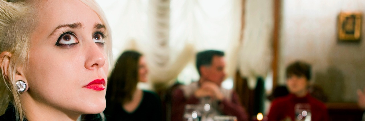 To Anyone Struggling With a Mental Illness During the Holidays Young woman looking up at dining table