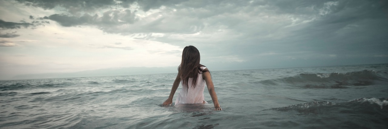 When Rain Storms Trigger Anxiety woman standing in the ocean