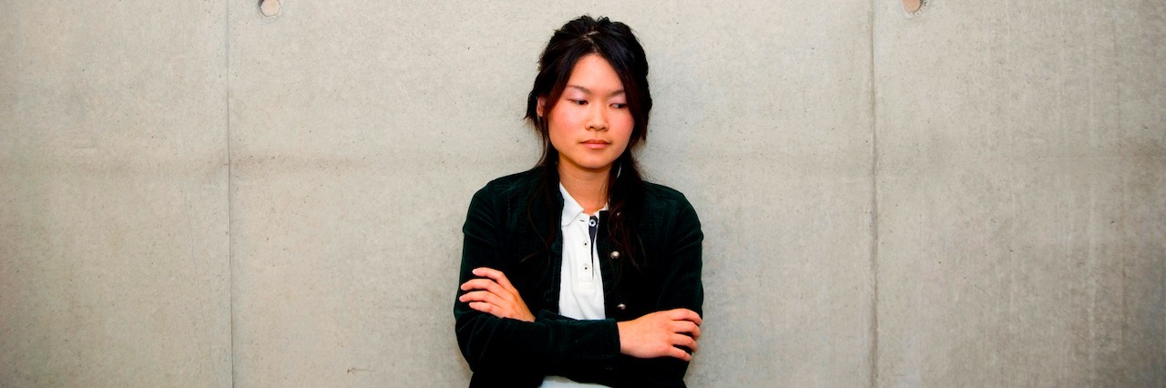 a woman sitting against a wall