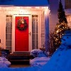 the house front door decorated with Christmas wreath, lights and a snowman