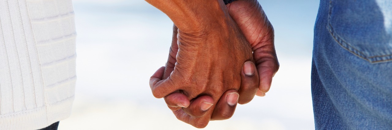 man and woman holding hands at beach
