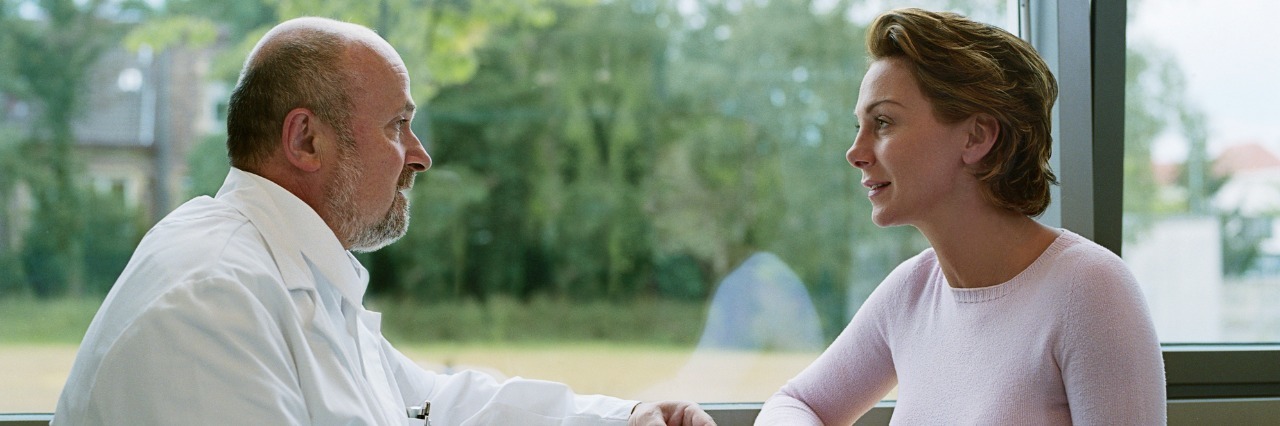 What Doctors Should Know About Erythromelalgia male doctor talking with female patient by a window