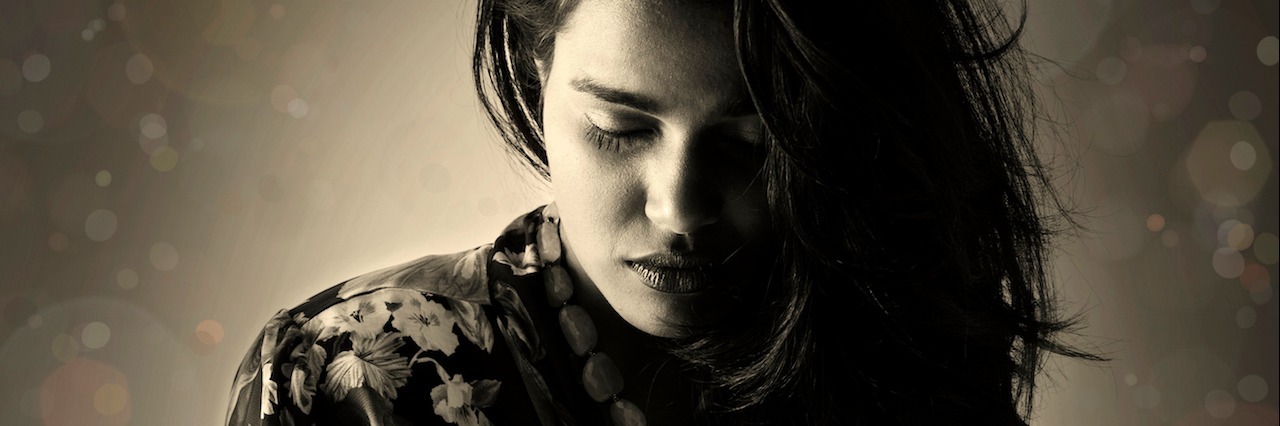 People Who Try to Kill Themselves Aren't Selfish or Cowards a young woman wearing a blouse looking down