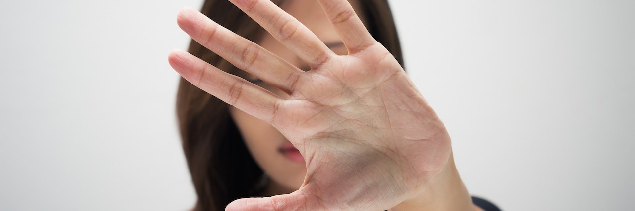 Why I'm Talking About Suicide A woman holding her face to cover her head