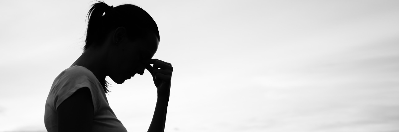 silhouette of sad woman with city skyline in background