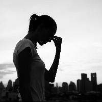 silhouette of sad woman with city skyline in background
