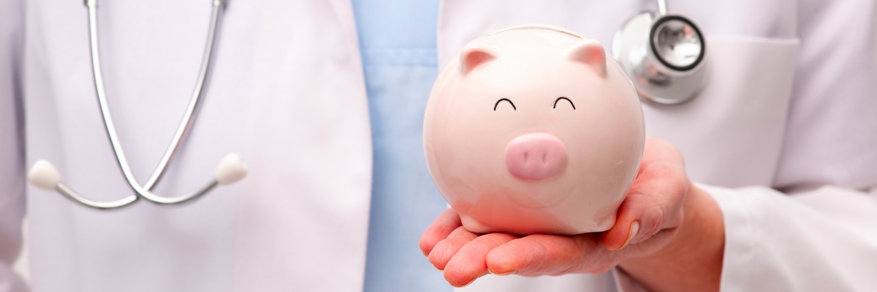 Health Care for People With Diseases and Disabilities Female doctor with stethoscope holding piggy bank