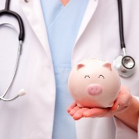 Female doctor with stethoscope holding piggy bank