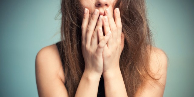 It's Still Scary to Say 'I'm Mentally Ill' close up of woman covering her mouth with her fingers