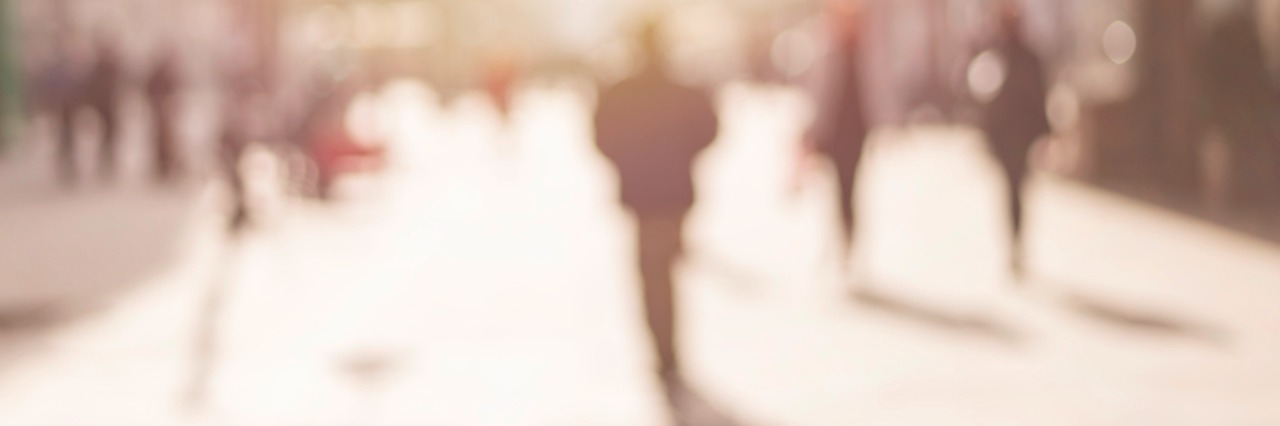Acknowledging How Cancer Has Affected My Feelings About Myself Blurred image of a city street scene and people walking.