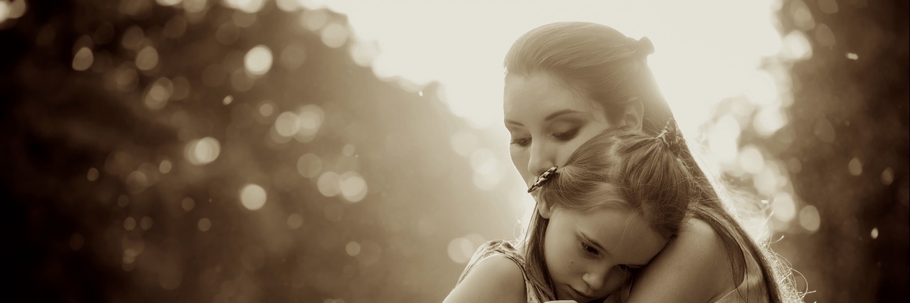 Experiencing Depression as the Parent of a Critically Ill Child Mother is cuddling her worried child outdoor in nature