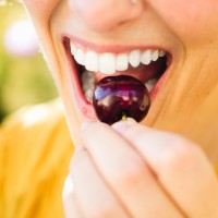 woman about to eat a cherry
