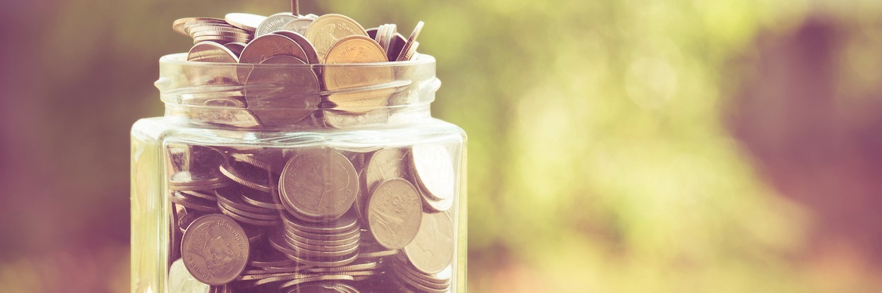 5 Tips for Managing Money While You're Recovering From Addiction jar of money with a plant growing out of it